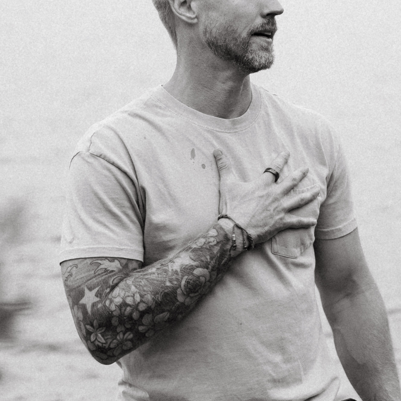 Jason Blydell with hand over heart, by the coast
